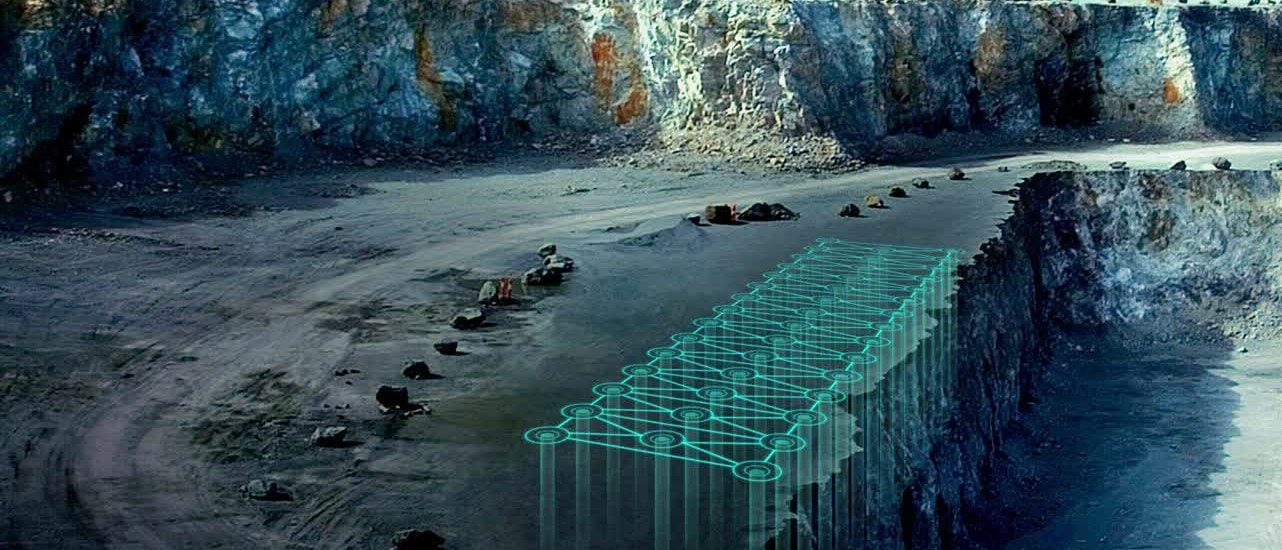 Quarry bench with a digital blast-hole pattern overlaid along the face